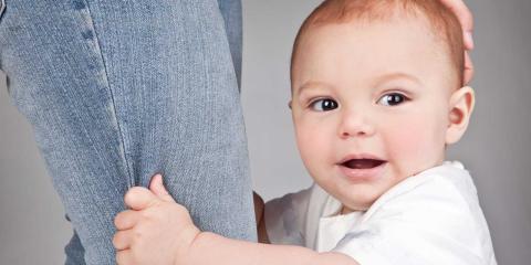 Baby clinging to their parent's leg