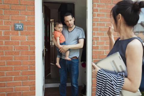 Mum waving to dad and toddler at the door