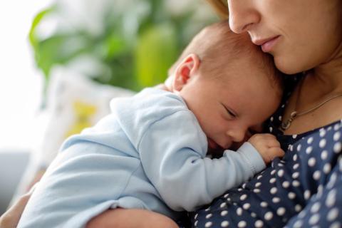 Image of a mum holding a sleeping baby.
