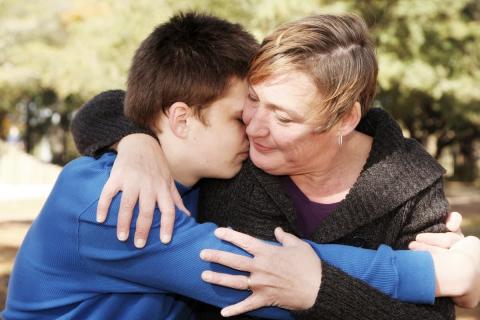 Mum hugging teenage son