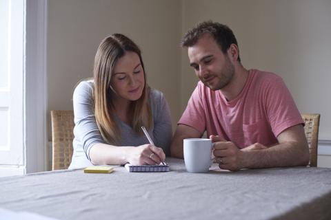 Image of two parents writing at a table.