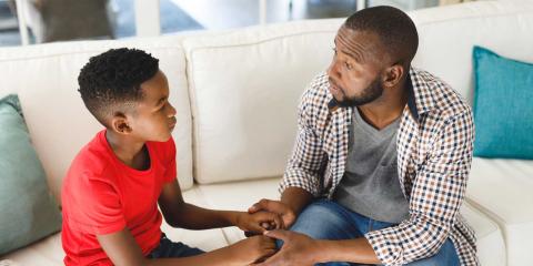 Father and son talking, holding hands