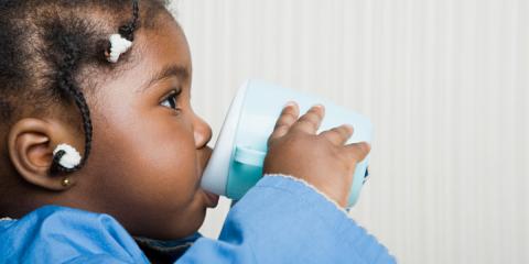 toddler drinking milk from a cup