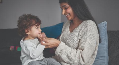 Photo of a mum and toddler playing on the couch 