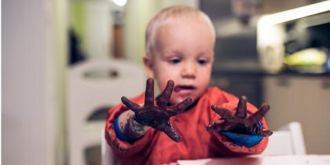 Photo of a toddler painting in the kitchen 