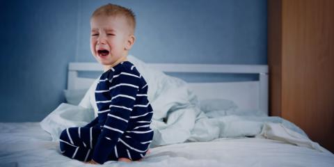 photo of toddler crying in bed