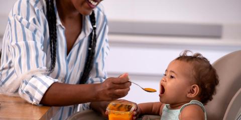 Mum feeding baby in highchair