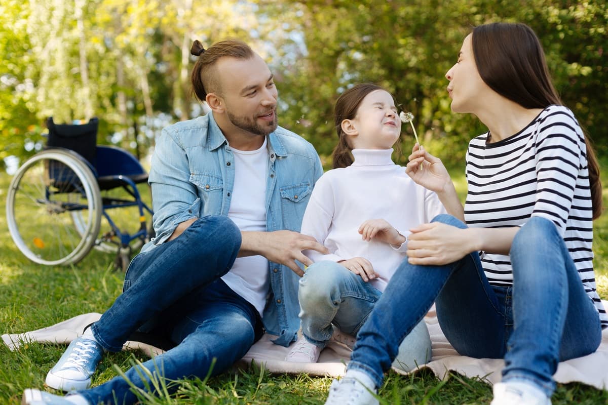 Family of dad, mum and girl enjoying a picnic outdoors
