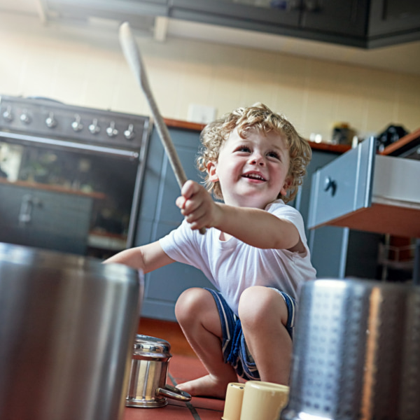 Photo of a toddler beating a pot as a drum 