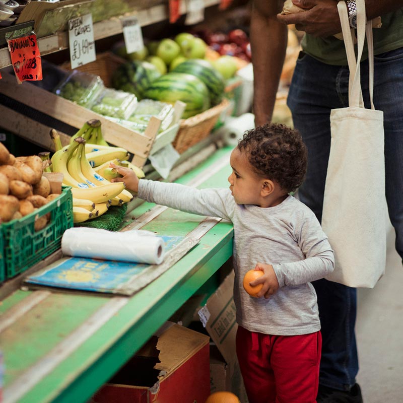 Child shopping in the supermarket with their dad