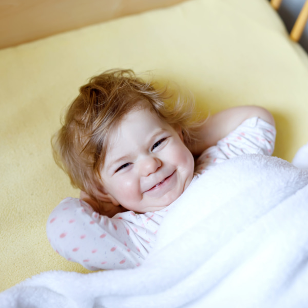 photo of toddler in bed smiling