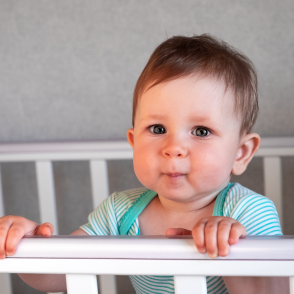 photo of toddler standing in cot