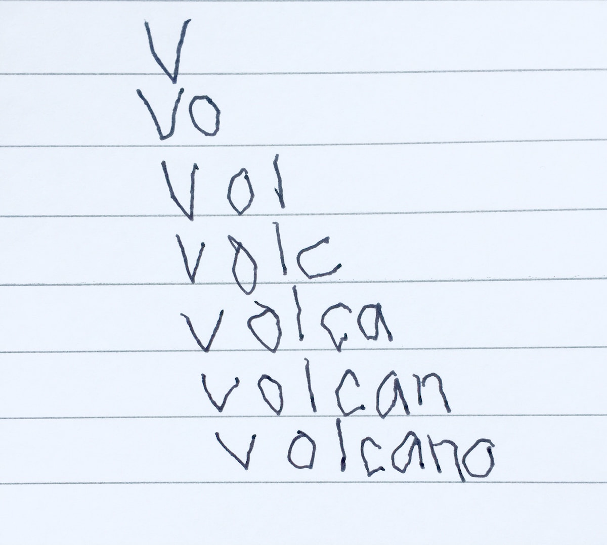 Image of the word 'volcano' written on a piece of paper in a child's handwriting.
